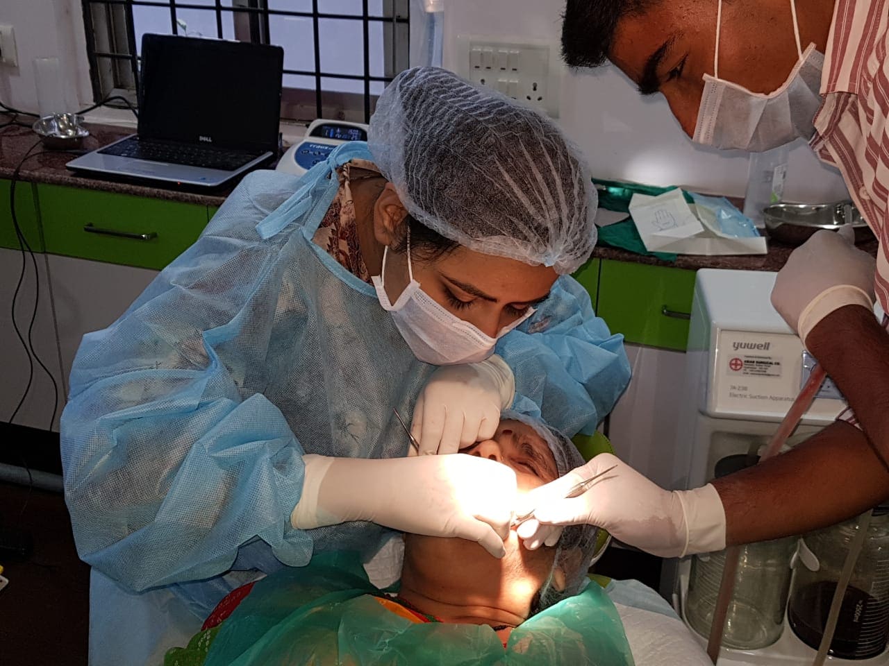 Indian dentist Dr. Pallack Razdan operating on a patient in dentistry clinic BDS DDS